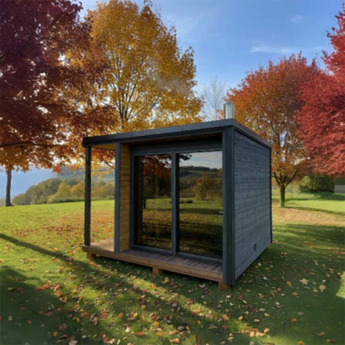 Woodnest Nora 3-4 Person Outdoor Sauna featuring a contemporary grey timber exterior, covered porch and large glass front in an autumn garden.